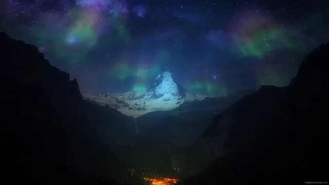 Aurora illuminating the sky around a mountain at night