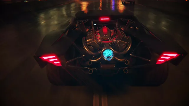 Batmobile racing along a wet Gotham City road at night