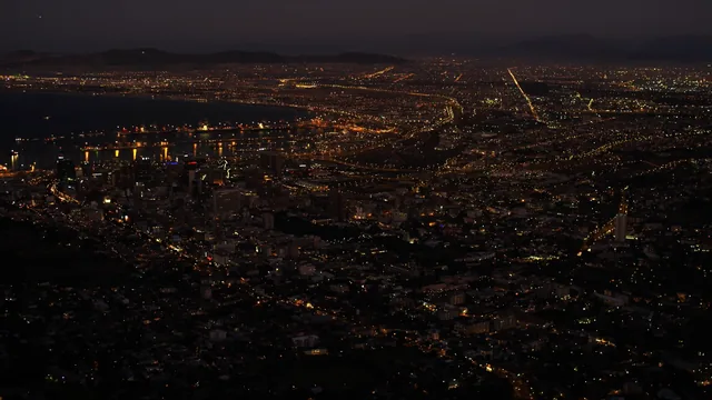 Cape Town skyline at night with Table Mountain, Atlantic Ocean, and stars