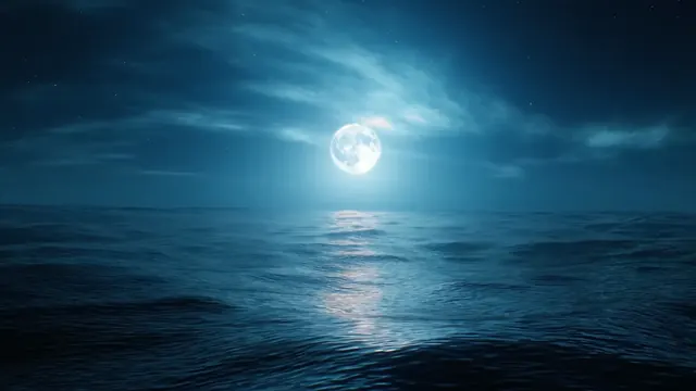 Full moon shining over gentle ocean waves at night