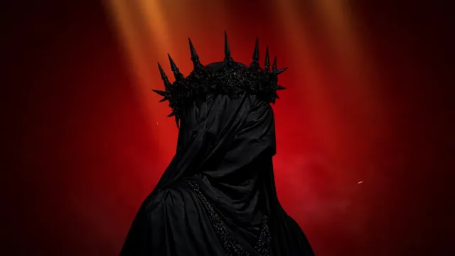 Faceless shadow king with a long spiked crown against an intense red background